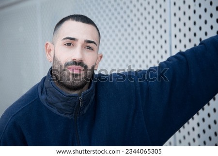 A portrait capturing a young caucasian man with excellent mental well-being, confidently meeting the camera's gaze, radiating positivity and self-assuredness