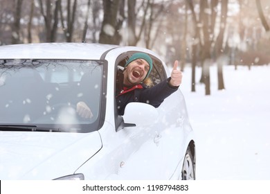 Portrait of car  driver with smile santa hat and thumb up through car window. On the road winter vacation and holidays concept.