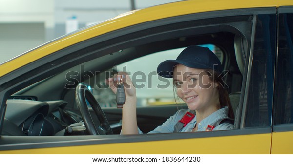 Portrait of car female\
mechanic in a car, with keys in her hands. Concept: repair of\
machines, fault diagnosis, repair specialist, technical maintenance\
and on-board computer.