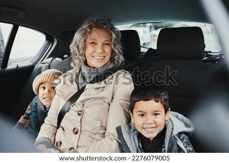 Portrait, car ride and grandmother relax with children or grandchildren while travel or on a road trip in the backseat. Bonding, happy and grandma traveling with kids or grandkids on a journey