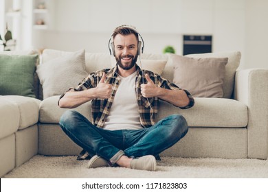 Portrait of carefree, cheerful, careless and good-looking brunet man in casual checkered brown shirt and jeans looking at camera, relax, showing thumbs up recommending his playlist - Shutterstock ID 1171823803