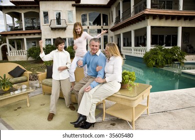 Portrait Of Carefree Family, Kids Playing Air Guitar On Patio