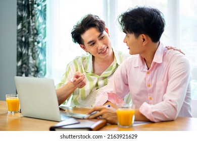 Portrait Of Carefree Gay Couple Talking Throught Their Home Finances