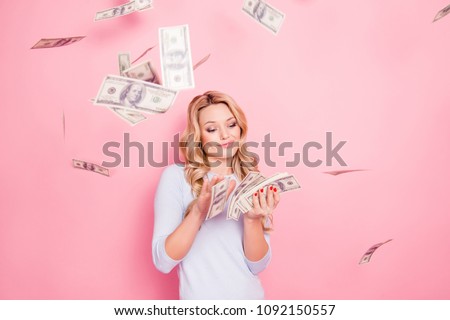 Portrait of carefree girlfriend, student wasting stack of much money, winner in casino lottery, having a lot of hundred dollars isolated on pink background