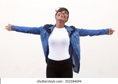 Portrait of a carefree young woman standing with arms spread open