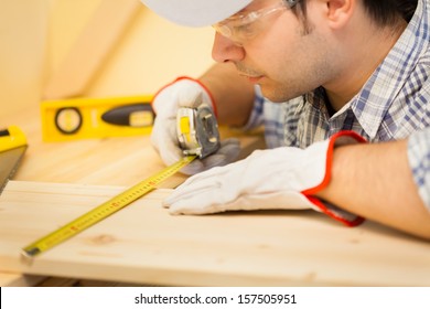 Portrait Of A Carpenter Using A Measuring Tape