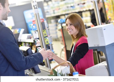 Portrait Of Cashier With Customer Paying Grocery Products