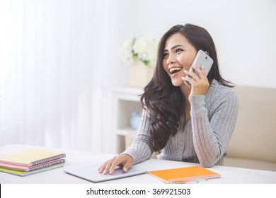 Portrait Of Casual Asian Woman Making A Phone Call At Home Using Smart Phone