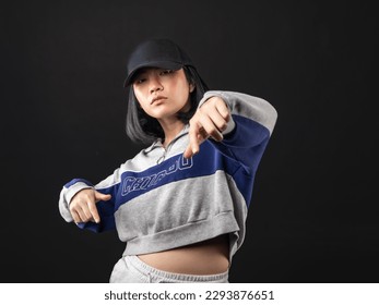 A portrait of a casual fashion-style Asian (Chinese Indonesian) Girl posing dan dancing with a Hip hop style. Isolated on a black background