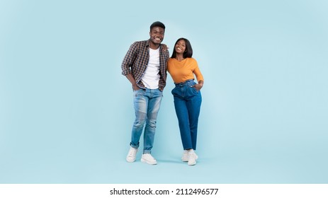 Portrait Of Casual Happy African American Young Couple Looking At Camera And Posing Standing Isolated Over Blue Studio Wall, Cheerful Black Lady Leaning On Her Boyfriend's Shoulder, Full Body Length