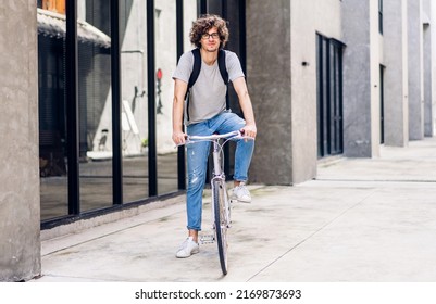 Portrait of casual hipster handsome businessman with backpack looking at camera while commuting riding bicycle on the street city way go to work.business travel transport bike concept - Powered by Shutterstock