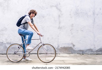 Portrait of casual hipster handsome businessman with backpack looking at camera while commuting riding bicycle on the street city way go to work.business travel transport bike concept - Powered by Shutterstock