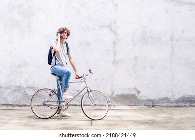 Portrait Of Casual Hipster Handsome Businessman With Backpack Talk On Smartphone While Commuting Riding Bicycle On The Street City Way Go To Work.business Travel Transport Bike Concept