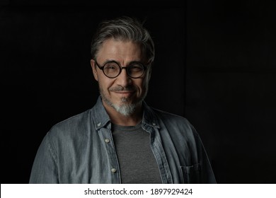 Portrait Of Casual Older Man With Beard Against Dark Background.