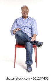 Portrait Of A Casual Senior Sitting On A Chair On White Background.