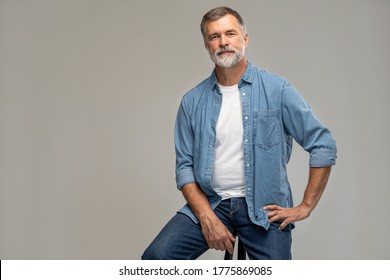 Portrait of a casual senior sitting on a chair on white background. - Shutterstock ID 1775869085