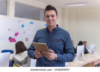 Portrait Of Casual Turkish Male Student Holding Tablet Or Ipad Inside Modern Computerlab Classroom. Technology And Education Concept