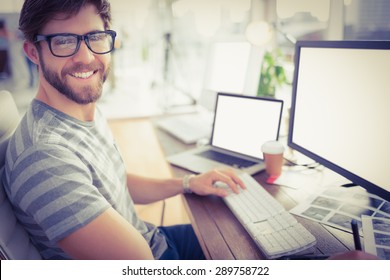 Portrait Of A Casual Young Businessman Using Computer In Office