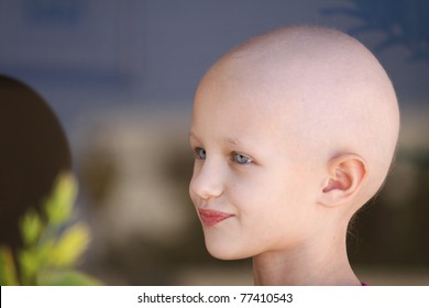 Portrait Of A Caucasian Child Suffering Hair Loss Due To Chemotherapy Treatment To Cure Cancer