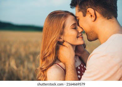 Portrait of a caucasian couple, man and woman, reach out close to each other for kiss. Standing in the wheat field. Love is in the air. - Shutterstock ID 2164669579