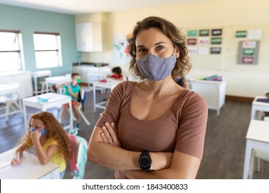 Portrait Of A Caucasian Female Teacher Wearing Face Mask At School, Teaching Children At School Classroom. Education Back To School Health Safety During Covid19 Coronavirus Pandemic.