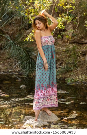 Portrait of Caucasian girl standing on a rock in a small stream  