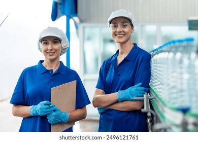 Portrait of Caucasian industry worker team work in factory warehouse. Attractive women industrial processing bottles of mineral water orders and food product at manufactory warehouse with happiness. - Powered by Shutterstock