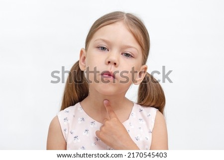 Portrait of caucasian little girl of 6 years pointing at throat by index finger showing voiceless and speechless. Concept dysarthria, logopedics