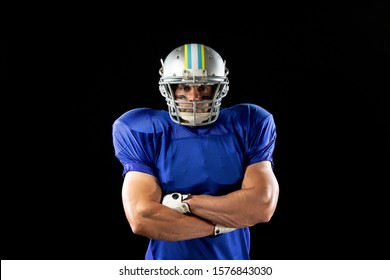 Portrait Of A Caucasian Male American Football Player Wearing A Team Uniform, Pads And A Helmet, Standing With Arms Crossed And Eye Black Under His Eyes