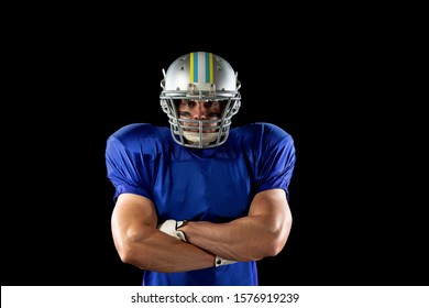 Portrait Of A Caucasian Male American Football Player Wearing A Team Uniform, Pads And A Helmet, Standing With Arms Crossed And Eye Black Under His Eyes