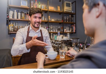 Portrait of caucasian male barista serving cup of fresh coffee water to customer. Startup successful small business owner standing in cafe or restaurant. Handsome barista customer service concept.