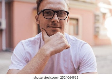 Portrait of Caucasian male blogger looking at camera while using digital tablet for messaging in web social networks, millennial young man pondering on app connection and online notification - Powered by Shutterstock