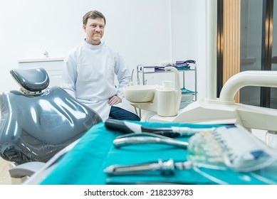 Portrait Of Caucasian Male Dentist Stand Cross Arm In Dental Exam Room. Handsome Young Man Dental Doctor Standing With Confident In Dental Examination Room, Smiling And Looking At Camera At Clinic.