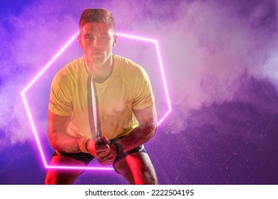 Portrait of caucasian male tennis player holding racket with illuminated hexagon, copy space. Composite, sport, competition, neon, glowing, confident, smoke and abstract concept. - Powered by Shutterstock