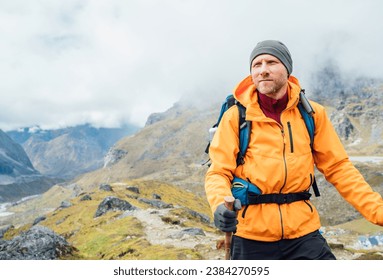 Portrait of caucasian man with backpack and trekking poles in Makalu Barun Park route near Khare. Mera peak climbing acclimatization active walk. Backpacker enjoying valley view. Active people concept - Shutterstock ID 2384270595