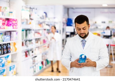 Portrait Of Caucasian Man Pharmacist Holding Bottle Of Sanitizer.