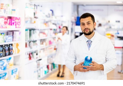 Portrait Of Caucasian Man Pharmacist Holding Bottle Of Sanitizer.