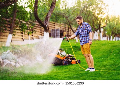 Portrait Of Caucasian Man Watering Lawn In Backyard Using Hose And Water