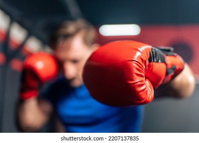 Portrait Caucasian professional sport young man exercising in fitness. Attractive athlete male in sportswear and boxing gloves workout by punching air to maintain strong muscle in fitness club or gym. - Powered by Shutterstock