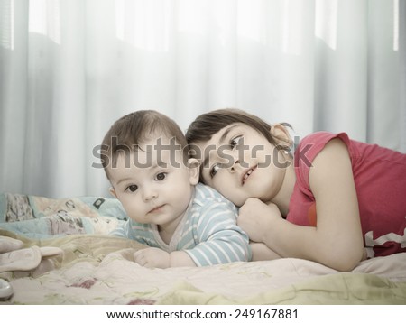 Similar – Little girl playing over boy lying in the bed