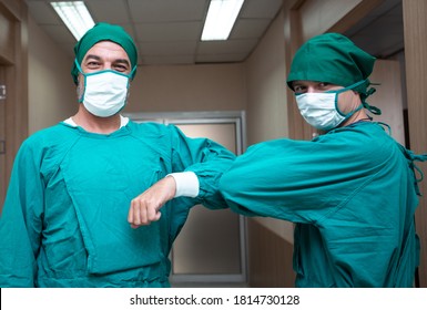 Portrait Caucasian Surgeon Doctor Elbow Bump Greeting For Social Distancing With Friend Co-worker In Hospital Hallway. New Normal Etiquette Concept During Coronavirus Or Covid. Healthcare And Medical