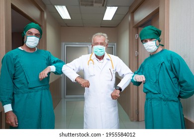 Portrait Caucasian Surgeon And Doctor Elbow Bump Greeting For Social Distancing With Friend Co-worker In Hospital Hallway. New Normal Etiquette Concept During Coronavirus. Healthcare And Medical
