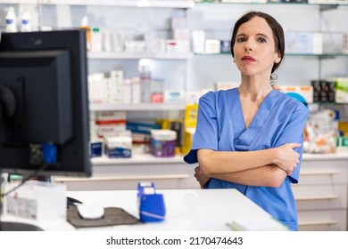 Portrait of caucasian woman druggist standing at counter in pharmacy.