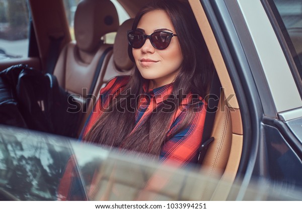 Portrait of a Caucasian woman in a flannel shirt and\
sunglasses 
