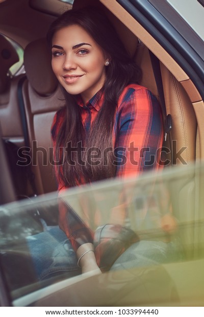 Portrait of a Caucasian woman in a flannel shirt sitting\
in the 