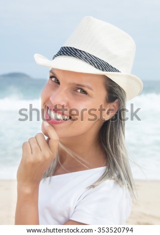 Portrait of a caucasian woman with hat at beach