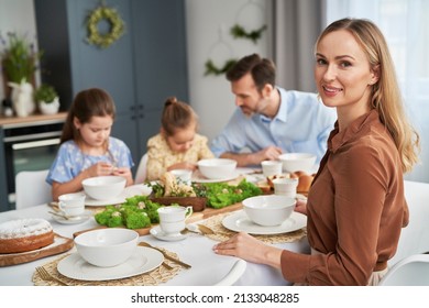 Portrait of caucasian woman and her family by the table in the background - Powered by Shutterstock