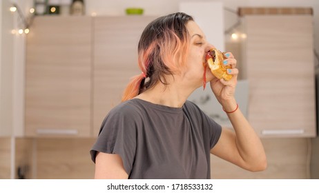 Portrait Of Caucasian Young Beautiful Woman Greedily Eagerly Eating Food During Quarantine Due To Coronavirus. Charming Happy Hungry Woman On Diet Laugh And Biting Off Big Meat Pie. Close Up.