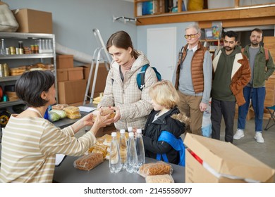 Portrait Of Caucasian Young Woman Receiving Food Donations And Help In Volunteer Center For Refugees