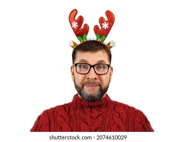 Portrait Of Charismatic Cheerful Bearded Man With Glasses, Woolen Red Sweater And Funny Deer Horns On His Head Isolated On White Background, Concept Of Christmas Or Holiday